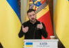 G7 Dangles Missiles Inside Ukraine Ukrainian leader delivering a speech at a podium with national flags in the background