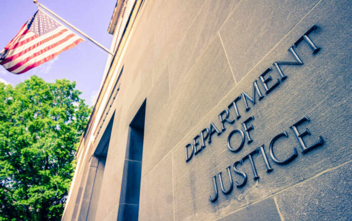 shutterstock_1384089728 Exterior view of the Department of Justice building with an American flag