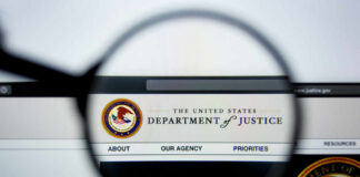 Close-up view of the Department of Justice website through a magnifying glass