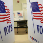 Voting booths with American flags and the word VOTE displayed