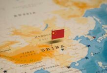 Pacific Showdown Looms — $122B On The Line Map of China with a small Chinese flag placed on it