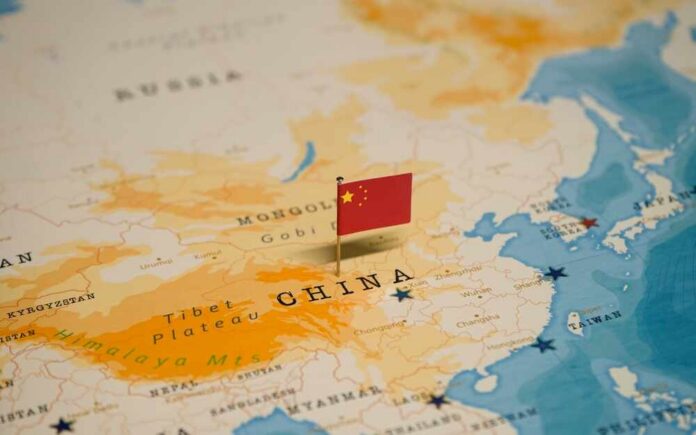 The,Map,And,Flag,Of,China. Map of China with a small Chinese flag placed on it