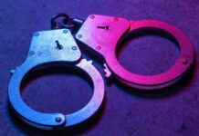 Graphic Street Assault Stuns Belfast Close-up of metallic handcuffs illuminated with neon lights