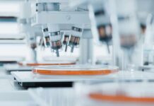 Deadly Flu Hits Australia—But Where? Automated laboratory equipment with robotic arms dispensing liquids into petri dishes
