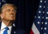 Pardon Sparks Fury: Congressman Walks Clean A political figure looking upward beside an American flag