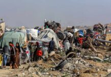 UN Exposes Hamas’ Public Killings Displaced families with belongings crowd a rubble-strewn road