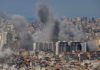 Smoke rising from buildings in a densely populated urban area