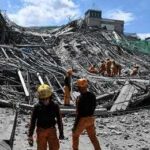 Rescue workers search a collapsed building site