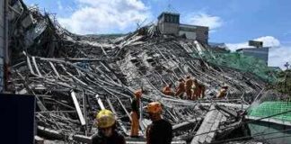 Rescue workers search a collapsed building site