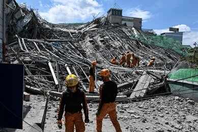 Rescue workers search a collapsed building site