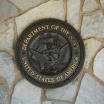 Bronze seal of the Department of the Navy mounted on a stone wall