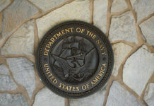 Bronze seal of the Department of the Navy mounted on a stone wall