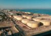 Ceasefire Shattered—Oil Jitters Ignite Aerial view of large oil storage tanks near a coastal area