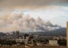 Toxic Haze Threatens World Cup Showdown City skyline with smoke clouds from a wildfire in the background