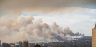 City skyline with smoke clouds from a wildfire in the background