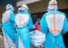 Ebola Jumps Borders — WHO Slams Alarm Medical workers in PPE assist a patient on a stretcher outdoors