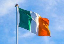 Irish flag on a flagpole against a blue sky