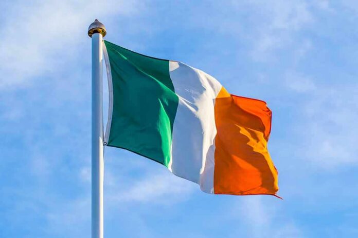 Irish flag on a flagpole against a blue sky