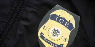 ICE officer badge on a dark uniform