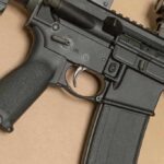 AR-style rifle close-up with grip, trigger, and magazine