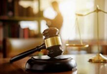 Judge's gavel on a desk with scales of justice in background