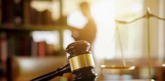 Judge's gavel on a desk with scales of justice in background