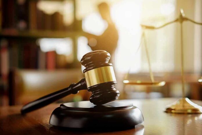 Judge's gavel on a desk with scales of justice in background
