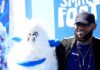 man posing with a white yeti mascot