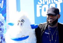 man posing with a white yeti mascot