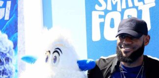 man posing with a white yeti mascot
