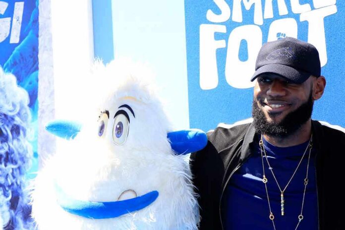 man posing with a white yeti mascot