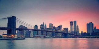 Brooklyn Bridge over East River at sunset with Manhattan skyline