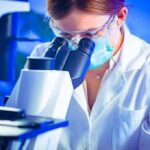 Scientist using a microscope in a lab
