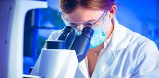 Scientist using a microscope in a lab