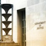 Voter Fraud Twist: Landlord Targeted Department of Justice building exterior with sign and metal sculpture