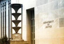 Department of Justice building exterior with sign and metal sculpture