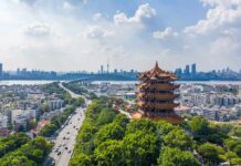 Beijing Slams Brakes On Presales Yellow Crane Tower overlooking a modern city skyline and river
