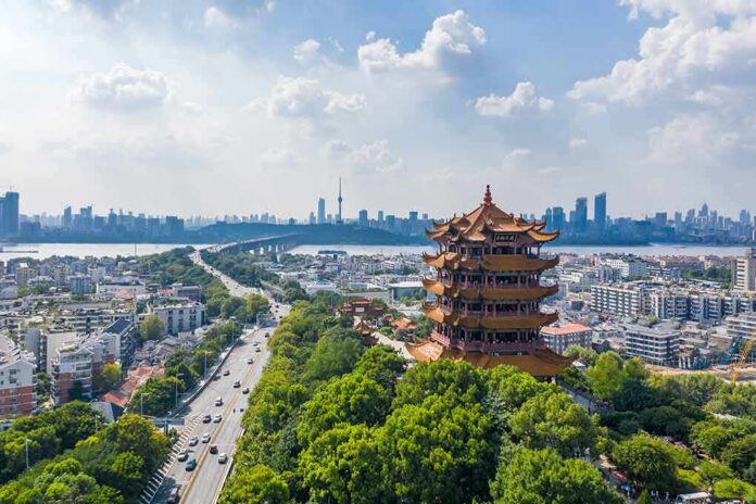 shutterstock_1506315968 Yellow Crane Tower overlooking a modern city skyline and river