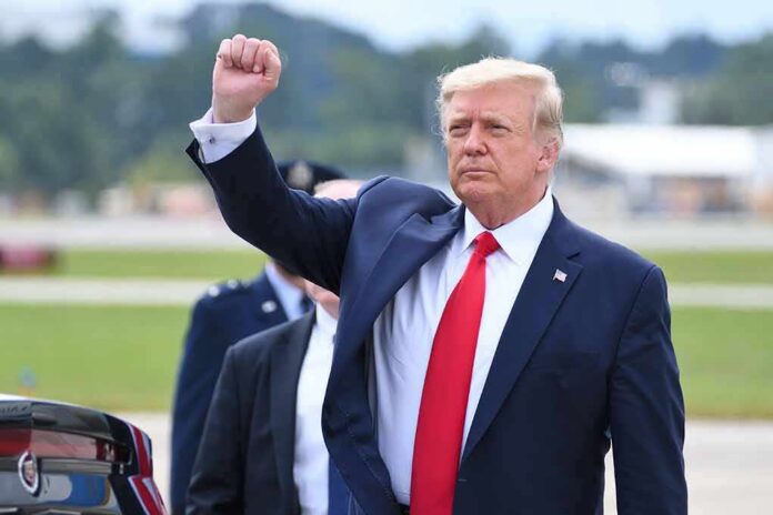 man in suit raising a clenched fist outdoors