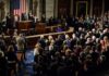 Legislators give a standing ovation in a grand chamber