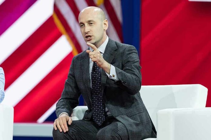 shutterstock_2270400565 Man in a gray suit speaking on stage