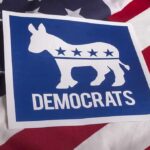 Democrats’ Label Bombshell Stuns Insiders Democrats donkey symbol on a blue sign over an American flag