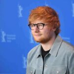Ed Sheeran Caught In Censorship Crossfire Ed Sheeran posing at a photo call against a blue backdrop