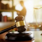 Judge's gavel on a desk with scales of justice in background