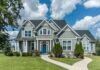 Gray suburban house with blue door and front yard