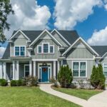 Gray suburban house with blue door and front yard