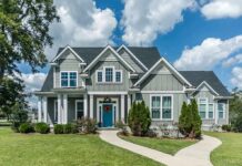 Gray suburban house with blue door and front yard