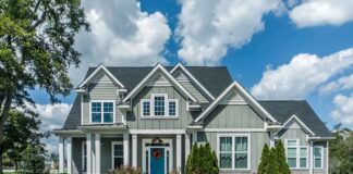 Gray suburban house with blue door and front yard