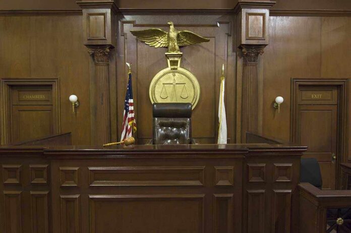 Interior of a courtroom featuring a judges bench and American flag