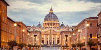 St. Peter's Basilica at the end of a wet street at dusk